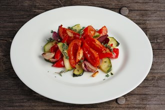 Grilled vegetables on white plate cutted on slices on wooden table