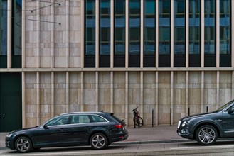Cars and bicycle in front of urban facade