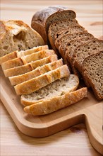 White and brown bread on wooden cutting board