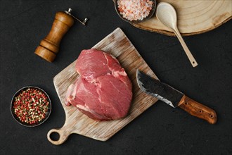 Overhead view of raw beef petite sirloin with ingredients on black background