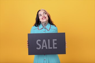 Beautiful woman holding a Sale sign. Commercial concept. Commerce