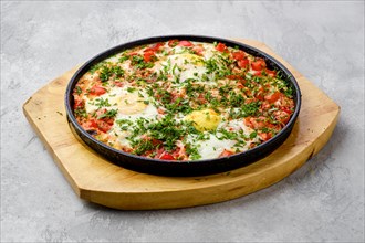 Eggs with tomato baked in oven in cast-iron skillet