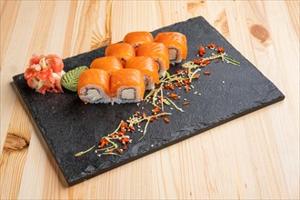 Set of rolls with wasabi and pickled ginger on stone serving board