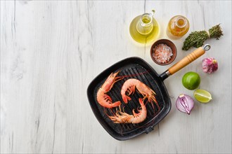Top view of unpeeled shrimp with head in cast iron skillet