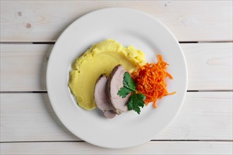 Top view of plate with oven made pork with mashed potato and spicy carrot