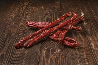 Air dried deer and pork sausage on wooden background