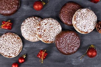 German round gingerbread called Lebkuchen with white and chocolate glazing surrounded by seasonal Christmas decoration