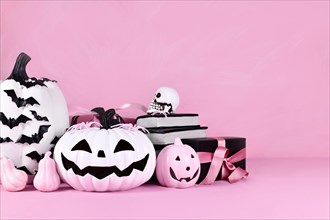 Pink Halloween decor with pink and black and white pumpkins and copy space
