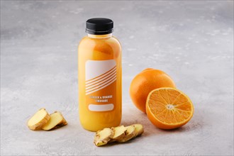 Small bottle with orange and ginger lemonade on the table