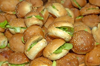 Large group of small breads stuffed with chicken and green lettuce leaves