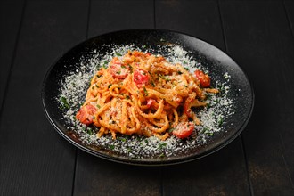 Spaghetti with tomato cherry and grated parmesan on a plate