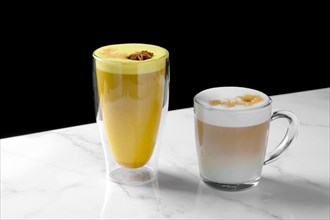 Variation of cappuccino with caramel and cinnamon on marble counter