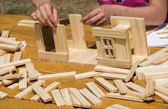 Hand holding wooden puzzle element in hand