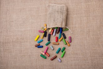 Crayons of various color out of a sack on a canvas
