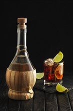 Bottle of homemade vodka and cold cocktail with lime and coffee liquor