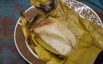 Stuffed tamale served on wooden table