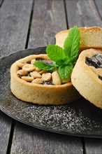 Caramel tart with peanut and mint on a plate