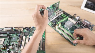 Male hardware engineer inserting circuit board memory slot