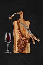 Tomahawk steak cut on slices on wooden board