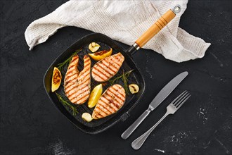 Overhead view of grilled trout steaks on pan