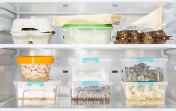 Front view organized plastic food containers fridge