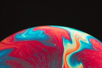 Gradient multicolored rippled soap bubble black background