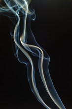 Trajectory of incense smoke in the air showing different shapes. France