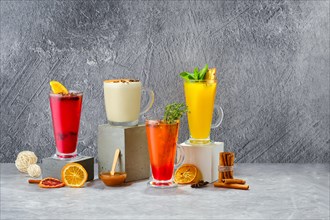 Composition with hot fruit and herbal winter drinks on shabby grey background