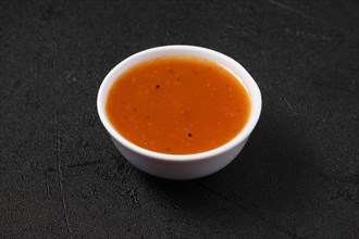 Small bowl with spicy orange sauce for poultry