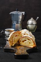 Fresh croissant with caramel filling cut on half with espresso