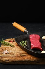 Raw boneless beef tri-tip steak on cast iron skillet
