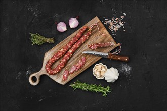 Overhead view of beef sun-dried sausage on wooden cutting board