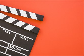 Clapperboard on red background with space