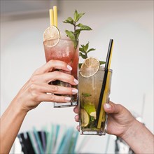 Close up women enjoying cocktail glasses