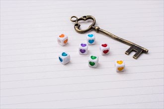 Key and colorful cubes with a heart placed on paper