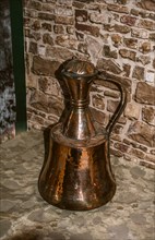 Very old style metal ewer water jar in view