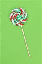 Lollipop with Christmas colors on green background