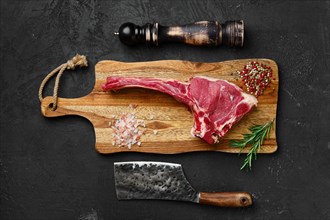Top view of raw prime ribeye steak on wooden cutting board