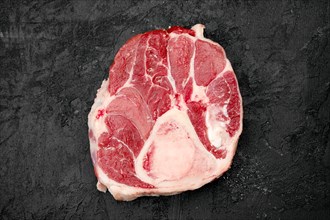 Raw beef ossobuco steak on black background