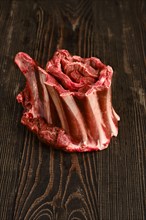 Raw rolld deer ribs over wooden background