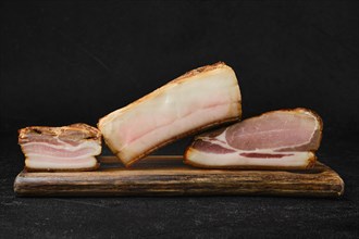 Assortment of smoked pork bacon and lard on wooden cutting board
