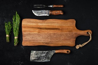 Top view of wooden cutting board with butcher tools