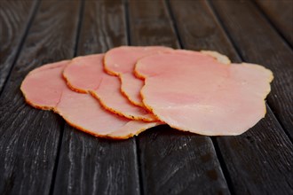 Selective focus photo of slices of fresh ham on wooden table