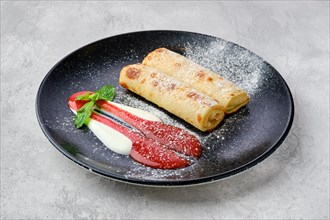 Thin crepe stuffed with cottage cheese served with strawberry jam and sour cream