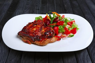 Juicy and crispy chopped pork fried on grill with fresh vegetables