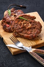 Grilled lamb neck on wooden cutting board