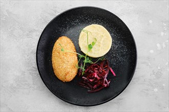 Kiev citlet with mashed potato and pickled beetroot on a plate