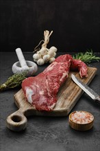 Raw beef tri-tip loin on wooden cutting board