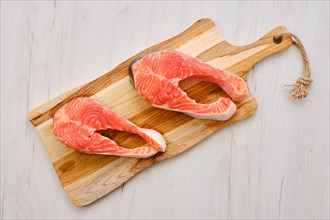 Top view of raw fresh salmon steak on wooden cutting board