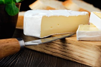 Close up of camembert cheese or brie cheese on wooden cutting board